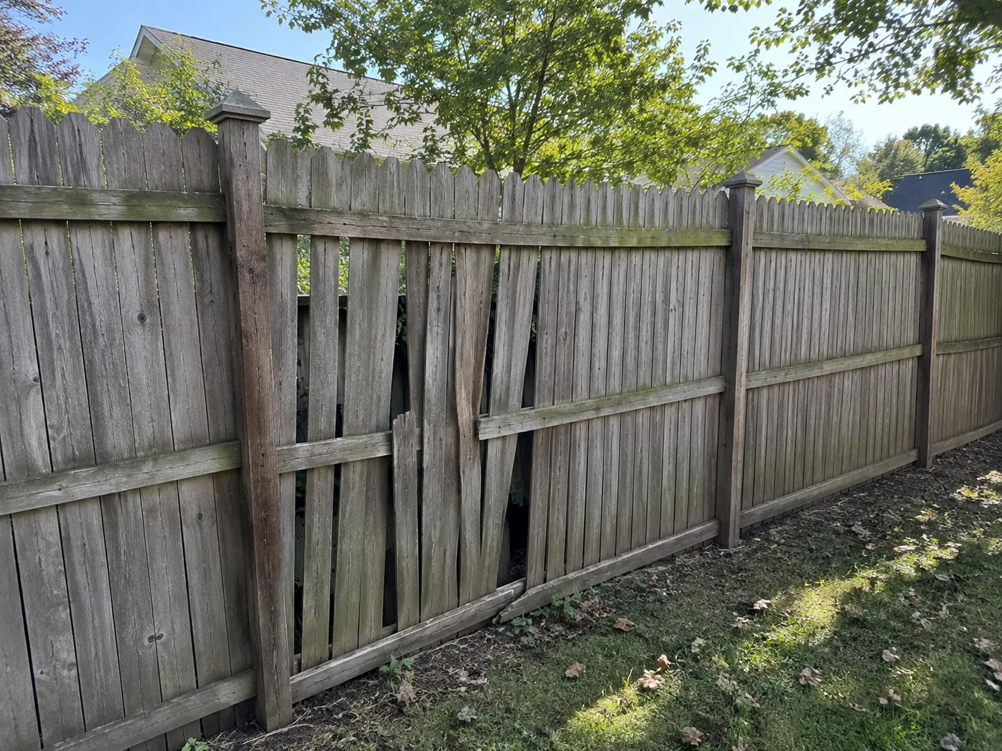 Old wood fence and failing panels in a Rochester-area backyard