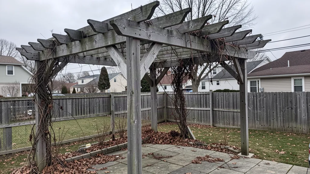 Aged wooden pergola with weathered beams and a leaning corner post over a patio